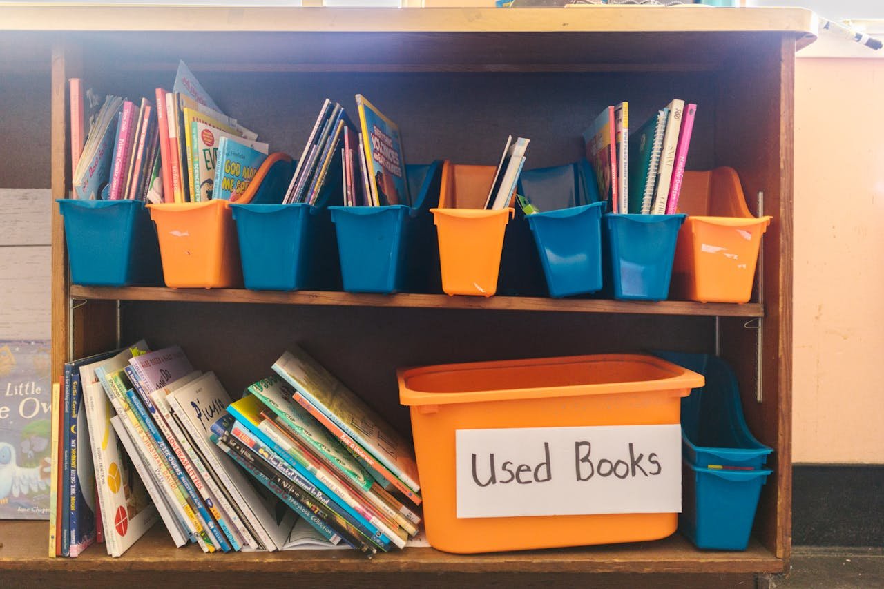 Crafting Captivating Headlines: Your awesome post title goes here Colorful bins filled with children's books on a wooden shelf, labeled as 'Used Books'.
