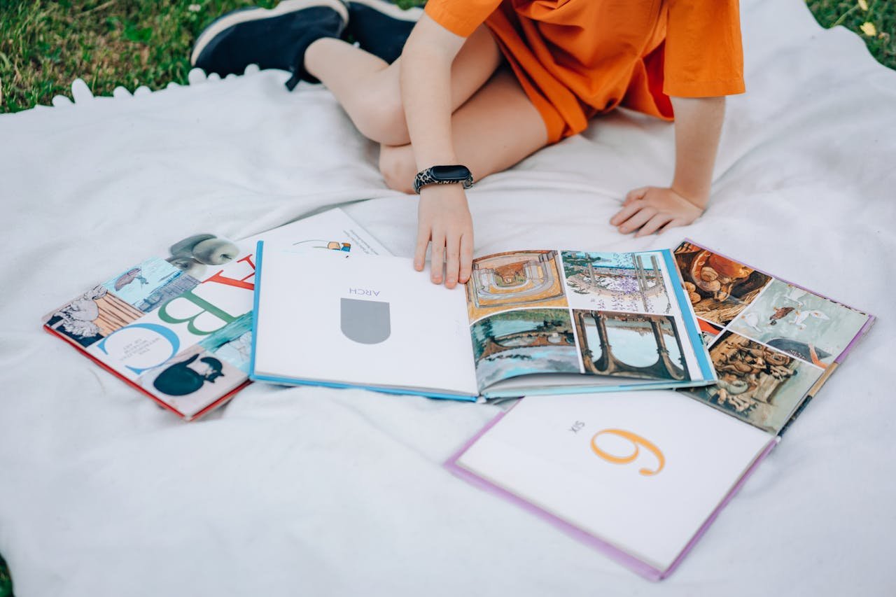The Art of Drawing Readers In: Your attractive post title goes here Young girl in orange dress reading books outdoors on a picnic blanket.